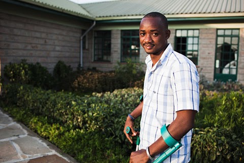 Photo: Person with a disability standing in front of building. Photo: Person with a disability standing in front of building.